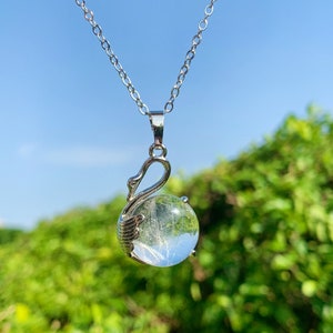 Pode incluir: Um colar de corrente de prata com um pingente de cristal transparente em forma de cisne. O cristal est&aacute; cheio de delicadas inclus&otilde;es brancas.