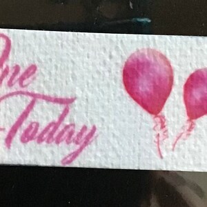 May include: White banner with pink balloons and the text "One Today" repeated twice.
