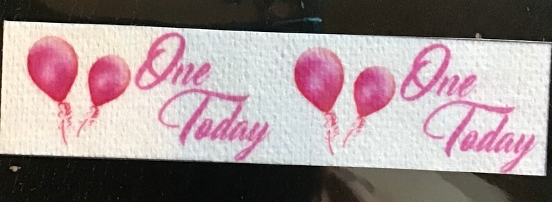 May include: White banner with pink balloons and the text "One Today" repeated twice.