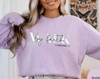 May include: A lavender sweatshirt with the text "Walk by faith 2 Corinthians 5:7" printed on the front.