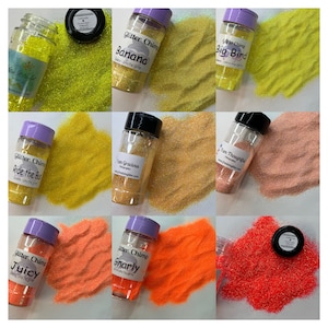 May include: Assortment of small glass jars filled with colorful glitter. The jars have labels with names like "Banana", "Big Bird", "Ride the Bus", "Juicy", and "Gnarly".