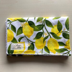 May include: White fabric burp cloth with a lemon print and a small label that says "Lucy's Littlelady" with a website address.