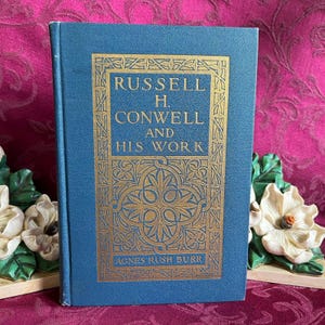 May include: A blue hardcover book with gold lettering on the cover. The title is "Russell H. Conwell and His Work" by Agnes Rush Burr.