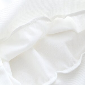 Peut inclure: Gros plan de l'int&eacute;rieur d'un v&ecirc;tement blanc, montrant le tissu doux et textur&eacute;.