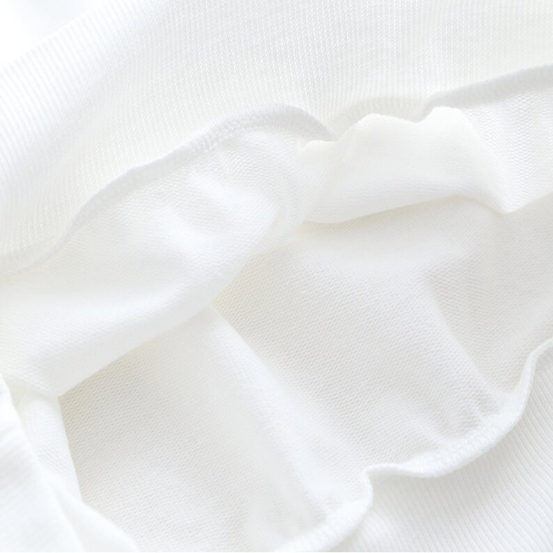 Peut inclure: Gros plan de l'int&eacute;rieur d'un v&ecirc;tement blanc, montrant le tissu doux et textur&eacute;.