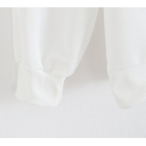 Peut inclure: Gros plan sur les poignets c&ocirc;tel&eacute;s blancs d'une chemise &agrave; manches longues.