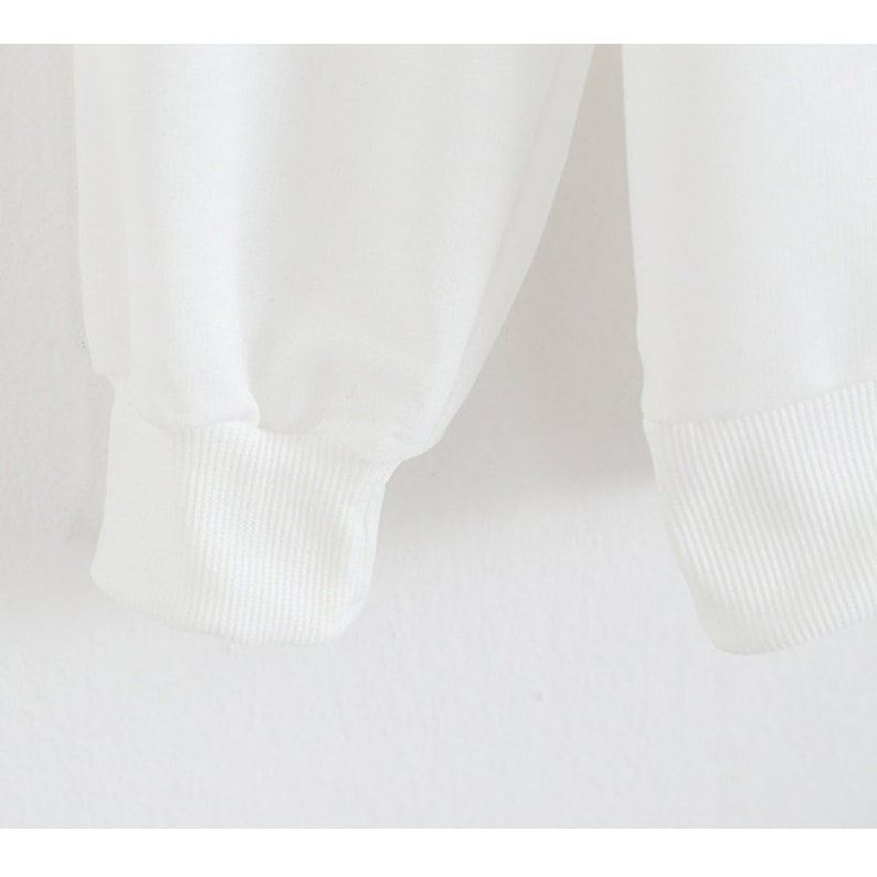 Peut inclure: Gros plan sur les poignets c&ocirc;tel&eacute;s blancs d'une chemise &agrave; manches longues.