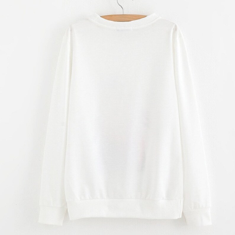 Peut inclure: Sweat-shirt blanc &agrave; manches longues avec un col rond.