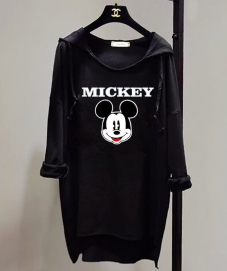 Puede incluir: Sudadera con capucha negra con un gr&aacute;fico de Mickey Mouse blanco y la palabra "MICKEY" impresa en blanco.