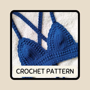 May include: A handmade, blue crochet top with a criss-cross back design. The top features a textured stitch pattern and straps. The text "CROCHET PATTERN" is displayed in a white rectangle at the bottom of the image. The top is displayed on a white, textured surface.