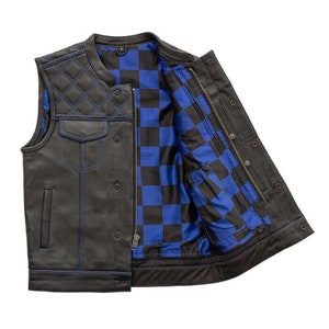 Può includere: Un giubbotto da motociclista in pelle nera con una fodera a scacchi blu e nera. Il giubbotto ha un design trapuntato sulle spalle e una chiusura a zip.
