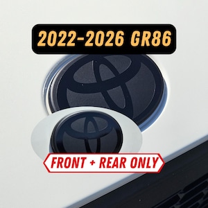May include: Black Toyota emblem replacements for 2022-2026 GR86 models. The image shows two black emblems, one larger and one smaller, with the Toyota logo. Text on the image reads "2022-2026 GR86" and "FRONT + REAR ONLY".