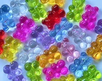 May include: Assortment of colorful gummy bear charms in various colors, including red, blue, green, yellow, pink, and purple. The charms are made of clear plastic and have a gummy bear shape.