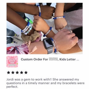 Puede incluir: Cuatro pulseras de cuentas azules con cuentas de letras blancas que deletrean nombres. Las pulseras se llevan en las mu&ntilde;ecas de cuatro personas. La imagen incluye una calificaci&oacute;n de cinco estrellas y el texto "Pedido personalizado para [ocultado], Letras de ni&ntilde;os..."