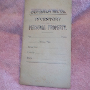 May include: A vintage, off-white paper form with the text "INVENTORY of PERSONAL PROPERTY." printed in black. The form has blank lines for filling in information about a property, including the location, acreage, section, township, county, and state.