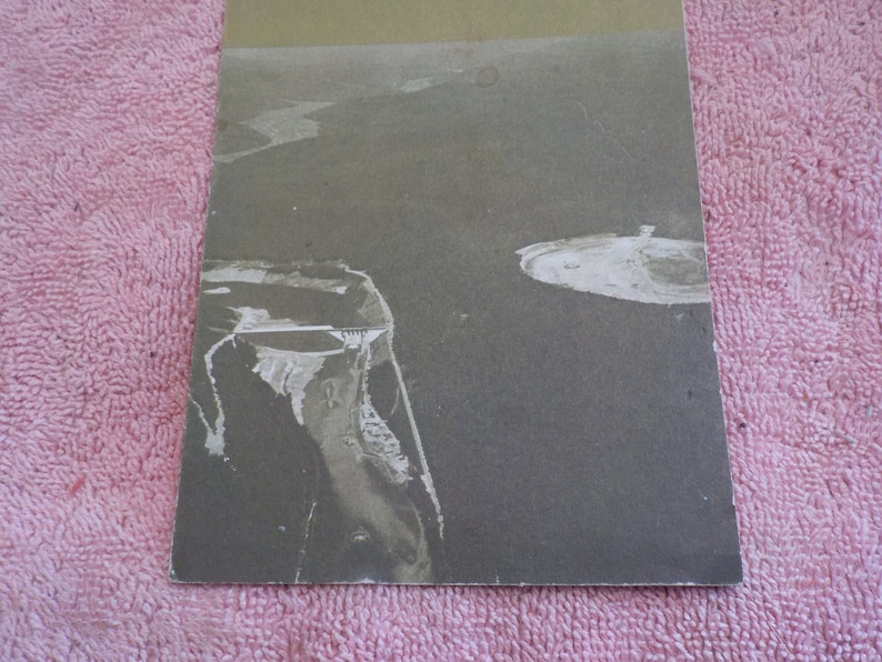 Puede incluir: Una fotograf&iacute;a a&eacute;rea en blanco y negro de una costa rocosa con una peque&ntilde;a isla en la distancia.