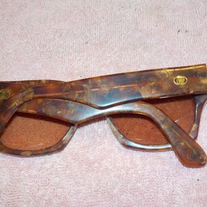 Puede incluir: Un par de gafas de sol de carey marr&oacute;n con detalles dorados. Las gafas tienen un patr&oacute;n veteado &uacute;nico y est&aacute;n en buen estado.