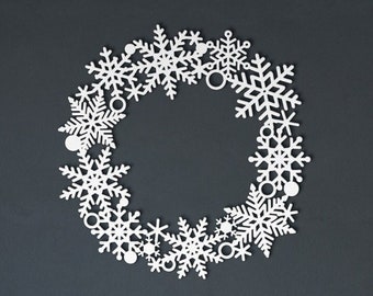 May include: White paper snowflake wreath with a circular shape. The snowflakes are arranged in a circle, creating a festive and decorative design.