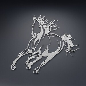 Op de afbeelding: Een zilverkleurig metalen wanddecoratie die een rennend paard afbeeldt. Het paard wordt getoond in een dynamische pose, met uitgestrekte benen en wapperende manen. Het kunstwerk is een silhouet, waarbij de vorm van het paard wordt gedefinieerd door de negatieve ruimte.