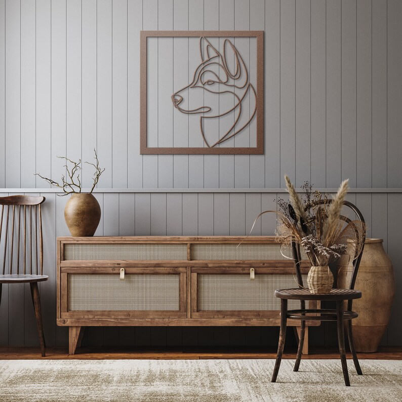 Pode incluir: Uma prateleira de parede de madeira com um design de arame cortado de uma cabe&ccedil;a de c&atilde;o em uma moldura marrom. A prateleira est&aacute; acima de uma c&ocirc;moda de madeira com quatro gavetas. A c&ocirc;moda tem uma frente de vime tran&ccedil;ado e puxadores de lat&atilde;o. Um vaso com galhos secos fica em cima da c&ocirc;moda, e uma cadeira de vime com um assento tran&ccedil;ado fica na frente da c&ocirc;moda.
