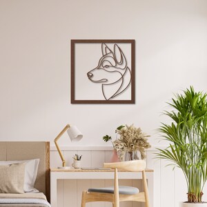 Pode incluir: Uma moldura de madeira marrom com um desenho de linha da cabe&ccedil;a de um c&atilde;o husky de perfil. Os olhos do c&atilde;o est&atilde;o fechados e o nariz &eacute; pontudo.