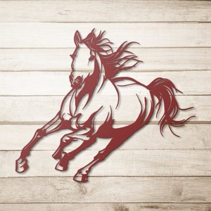 Op de afbeelding: Een kastanjebruine metalen uitsnede van een rennend paard. Het paard wordt afgebeeld in een dynamische pose met zijn manen en staart wapperend. De uitsnede is gemonteerd op een licht houten achtergrond.