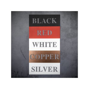 K&ouml;nnte beinhalten: F&uuml;nf Metallproben in einem vertikalen Stapel, beschriftet mit "BLACK", "RED", "WHITE", "COPPER" und "SILVER".