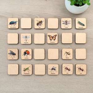 May include: A set of square wooden tiles featuring illustrations of various insects including a rhino beetle, bee, firefly, caterpillar, dragonfly, butterfly, fly, ladybug, mantis, grasshopper, mosquito, and two ants, each labeled with its name.