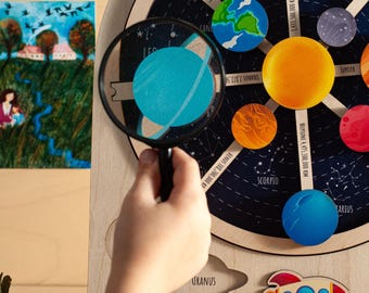 May include: A wooden solar system model with planets painted in different colors. The planets are connected to the sun by wooden rods. The model is on a black background with stars and constellations. The text on the model includes the names of the planets and their distances from the sun in kilometers.