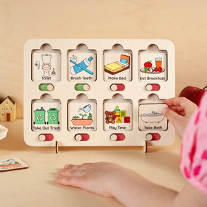 K&ouml;nnte beinhalten: Ein Holz-Aktivit&auml;tsbrett mit bunten Illustrationen und Textbeschriftungen f&uuml;r t&auml;gliche Routinen, wie "Toilette", "Z&auml;hne putzen", "Bett machen", "Fr&uuml;hst&uuml;ck essen", "M&uuml;ll rausbringen", "Pflanzen gie&szlig;en", "Spielzeit" und "Baden".