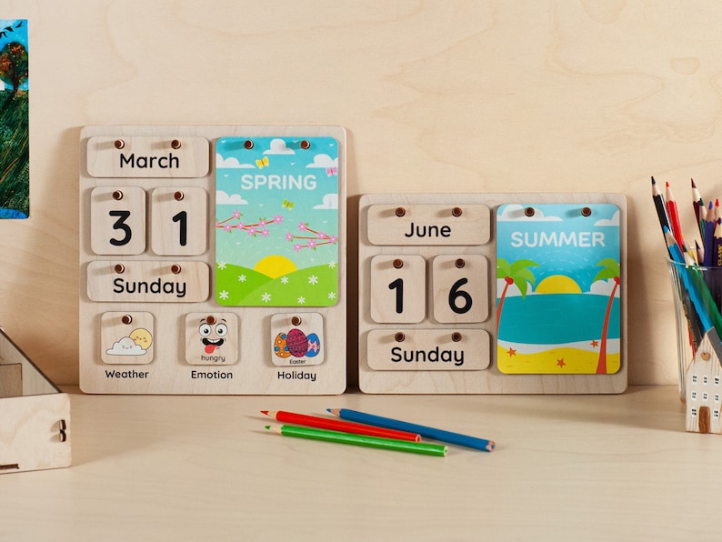 May include: A wooden calendar with removable cards for the day, month, and day of the week. The calendar also includes cards for weather, emotion, and holiday. The calendar is set to March 31st, Sunday, with a spring theme card. A second calendar is set to June 16th, Sunday, with a summer theme card.