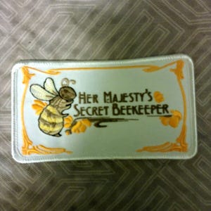 Vintage embroidered Her Majesty's Secret Beekeeper Iron on patch 4 1/2" X 2 1/2" l NOS