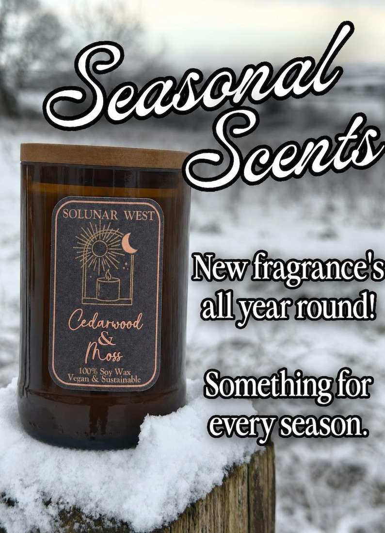 May include: A brown glass candle with a wooden lid, labeled "Cedarwood & Moss" with a black and gold label. The text "Seasonal Scents" is at the top. Additional text reads "New fragrance's all year round!" and "Something for every season."