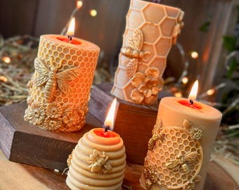 May include: Four honey-colored candles with a honeycomb design and gold bee accents. The candles are arranged on a wooden surface.