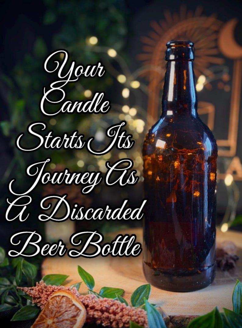 May include: A repurposed brown beer bottle with the text "Your Candle Starts Its Journey As a Discarded Beer Bottle." The bottle is lit from within, and sits on a wooden surface with greenery and dried flowers.