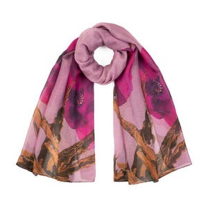Peut inclure: Une écharpe mauve avec un grand imprimé floral dans les tons de rose et de marron. L'écharpe est drapée, mettant en valeur le motif de grandes fleurs et de branches. L'écharpe est faite d'une matière douce.