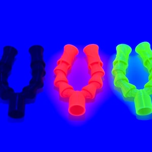 May include: Three flexible, Y-shaped tubes in black, neon orange, and neon green against a vibrant blue background. Each tube has a ribbed, accordion-like design. The tubes are likely for industrial or scientific use.
