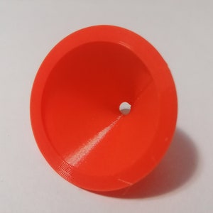 Peut inclure: Un entonnoir en plastique orange vif avec un petit trou au fond.