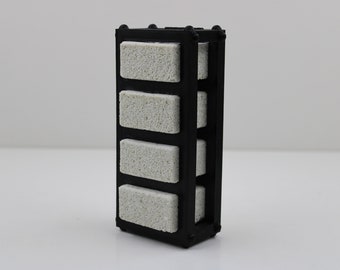 May include: A black plastic filter cartridge with five white ceramic filter pads. The filter cartridge is rectangular and has a grid pattern.