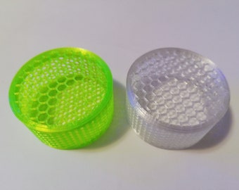 May include: Two 3D printed round containers with a honeycomb pattern. One container is green and the other is white.