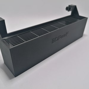 May include: A black plastic 3D printed fan shroud with a grid pattern and the text "3DReef" printed on the side.