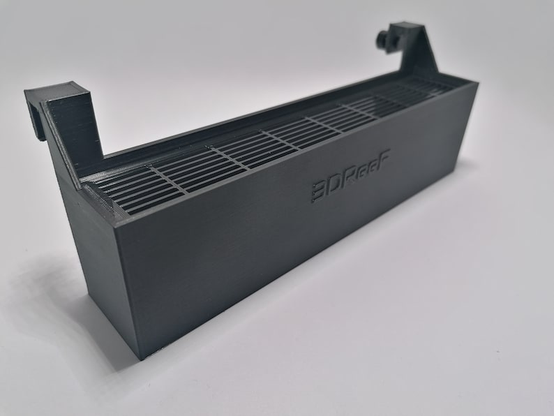 May include: A black plastic 3D printed fan shroud with a grid pattern and the text "3DReef" printed on the side.