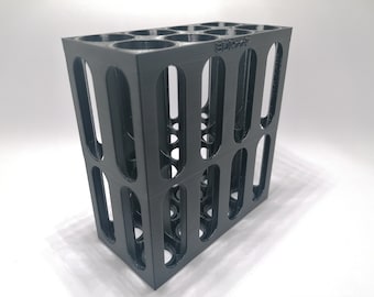 May include: A black, rectangular storage rack with multiple circular openings on top and bottom. The sides feature vertical, oval-shaped cutouts. The word "epikrack" is visible on the top. This item is likely designed for organizing small items.