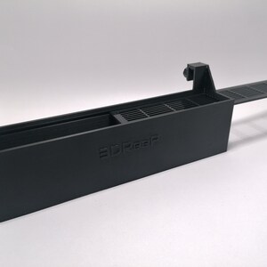 May include: A black plastic 3D printed filter holder with a removable lid and a grate. The holder has the word "3DReef" printed on the side.