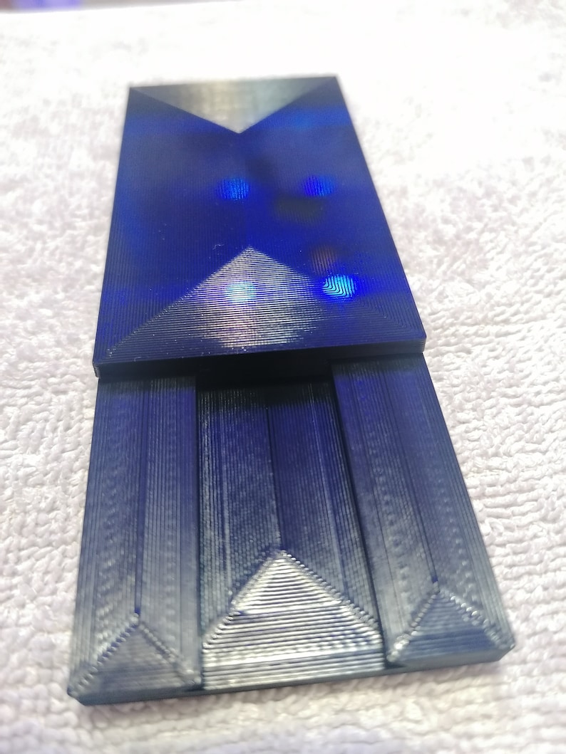 May include: A dark blue, geometrically shaped, 3D printed object with a textured surface.