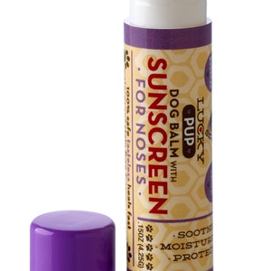 May include: Purple and white tube of Lucky Pup dog balm sunscreen for noses. The tube is labeled "Dog Balm with Sunscreen for Noses" and "100% safe, tasteless, heals fast". The tube is 1.5 oz (4.25g).