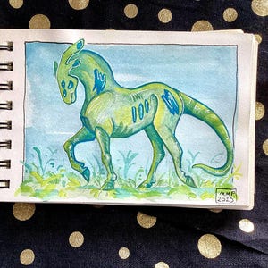Peut inclure: Une esquisse à l'aquarelle d'une créature verte et bleue ressemblant à un cheval ou un dinosaure, sur fond de ciel bleu et d'herbe. L'œuvre est dans un petit carnet de croquis, avec les initiales de l'artiste et l'année 2025 visibles.