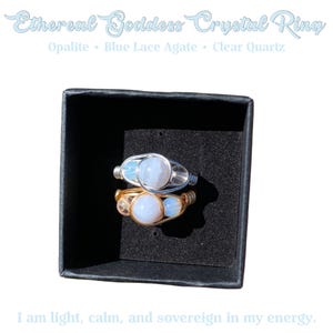 May include: Two crystal rings in a black box. One ring is silver with a blue stone, and the other is gold with a blue stone. The text on the image reads "Ethereal Goddess Crystal Ring" and lists the stones used.