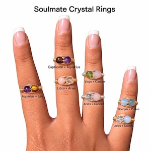 May include: Soulmate Crystal Rings featuring wire-wrapped bands with two small gemstone beads. The rings are labeled with zodiac sign pairings including Aquarius + Leo, Capricorn + Aquarius, Libra + Aries, Virgo + Cancer, Aries + Cancer, Scorpio + Pisces, and Aries + Scorpio.