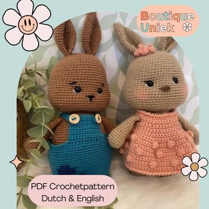 Könnte beinhalten: Zwei gehäkelte Hasenpuppen. Ein Hase trägt eine blaue Latzhose mit weißen Knöpfen, der andere trägt ein rosa Kleid. Die Hasen haben lange Ohren und sind braun und hellbraun. Das Bild enthält den Text "Boutique Uniek" und "PDF Crochetpattern Dutch & English".